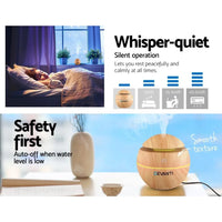 Diffuser emitting fine mist with soft lighting in a cozy living room setting.