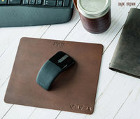 Dark brown genuine leather mouse pad with labeling showing material and features.