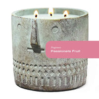 Hand-painted cement vessel candle with a stone face design, natural cement color.