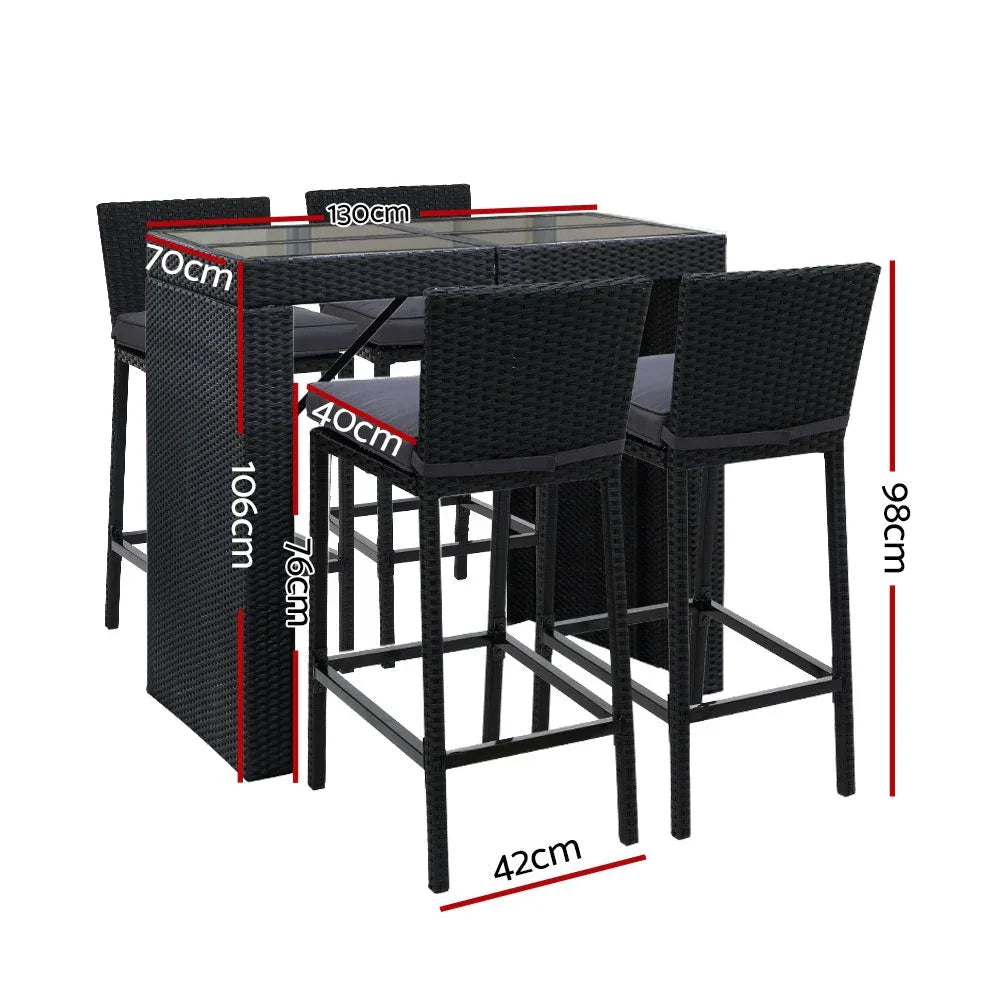Close-up of cushioned rattan bar stools with inclined backrests around glass table