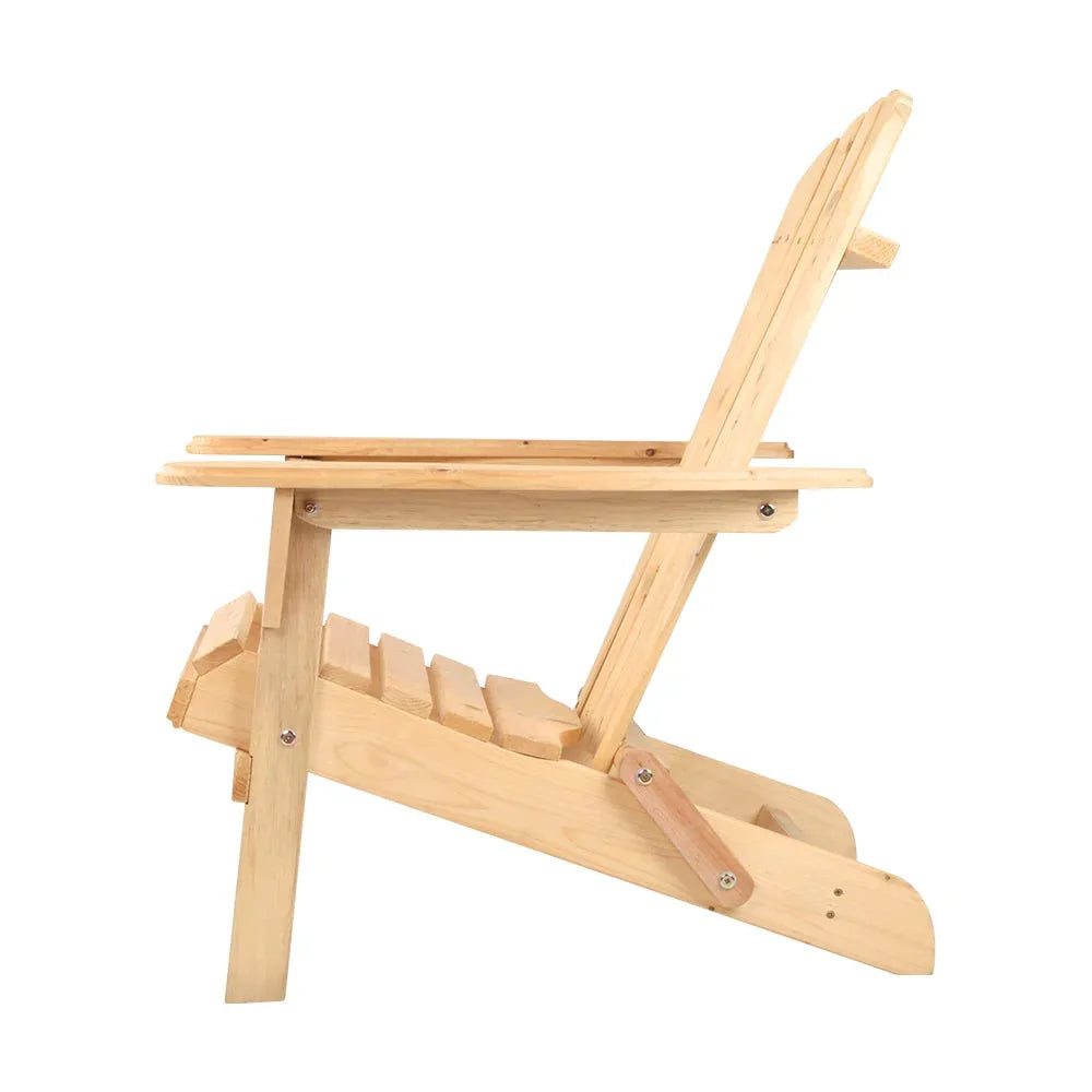 Two wooden beach chairs with armrests placed side by side on green lawn under trees.