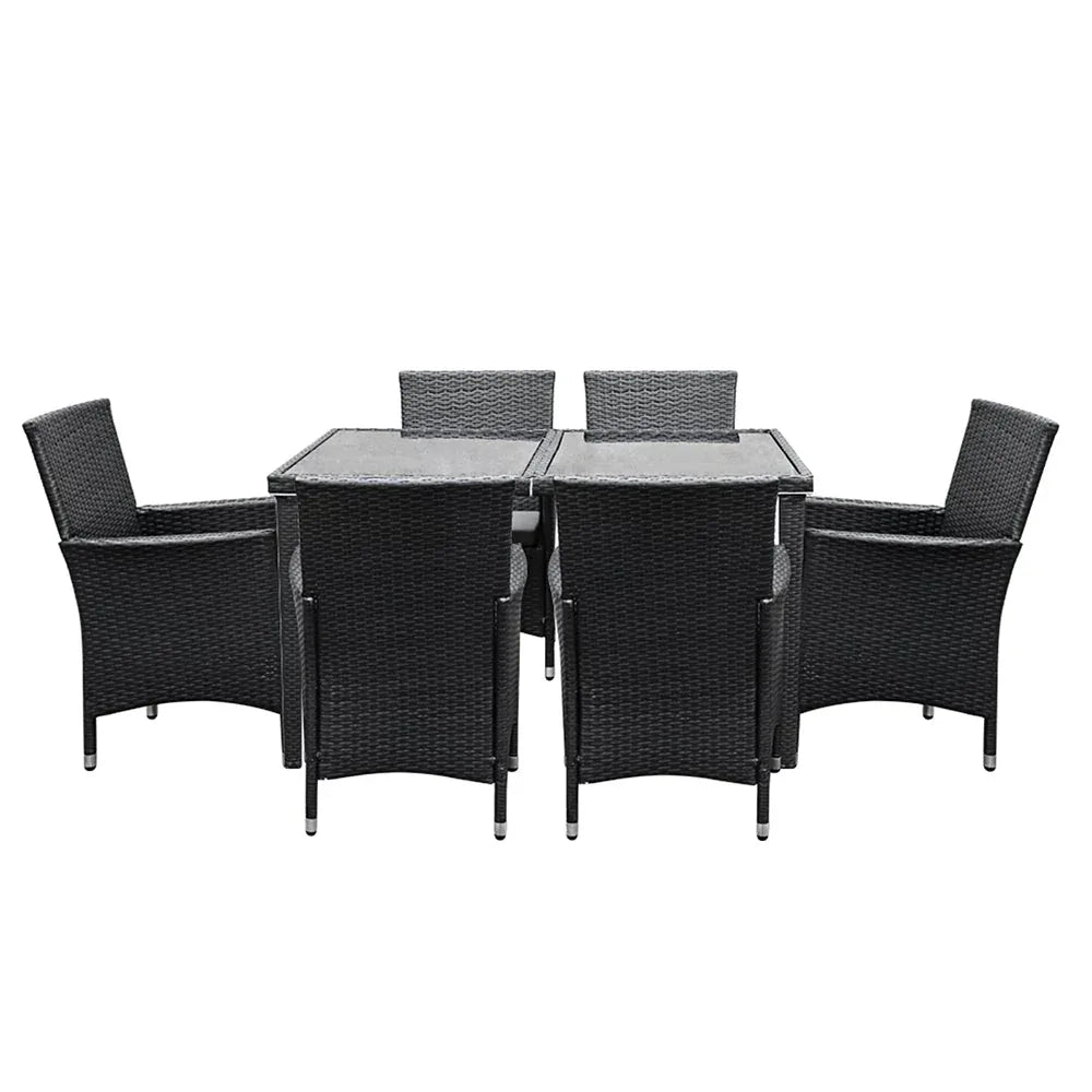 Glass-top outdoor dining table with aluminum frame, surrounded by cushioned rattan chairs