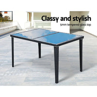 Angled shot of outdoor dining table and six cushioned chairs on wooden deck