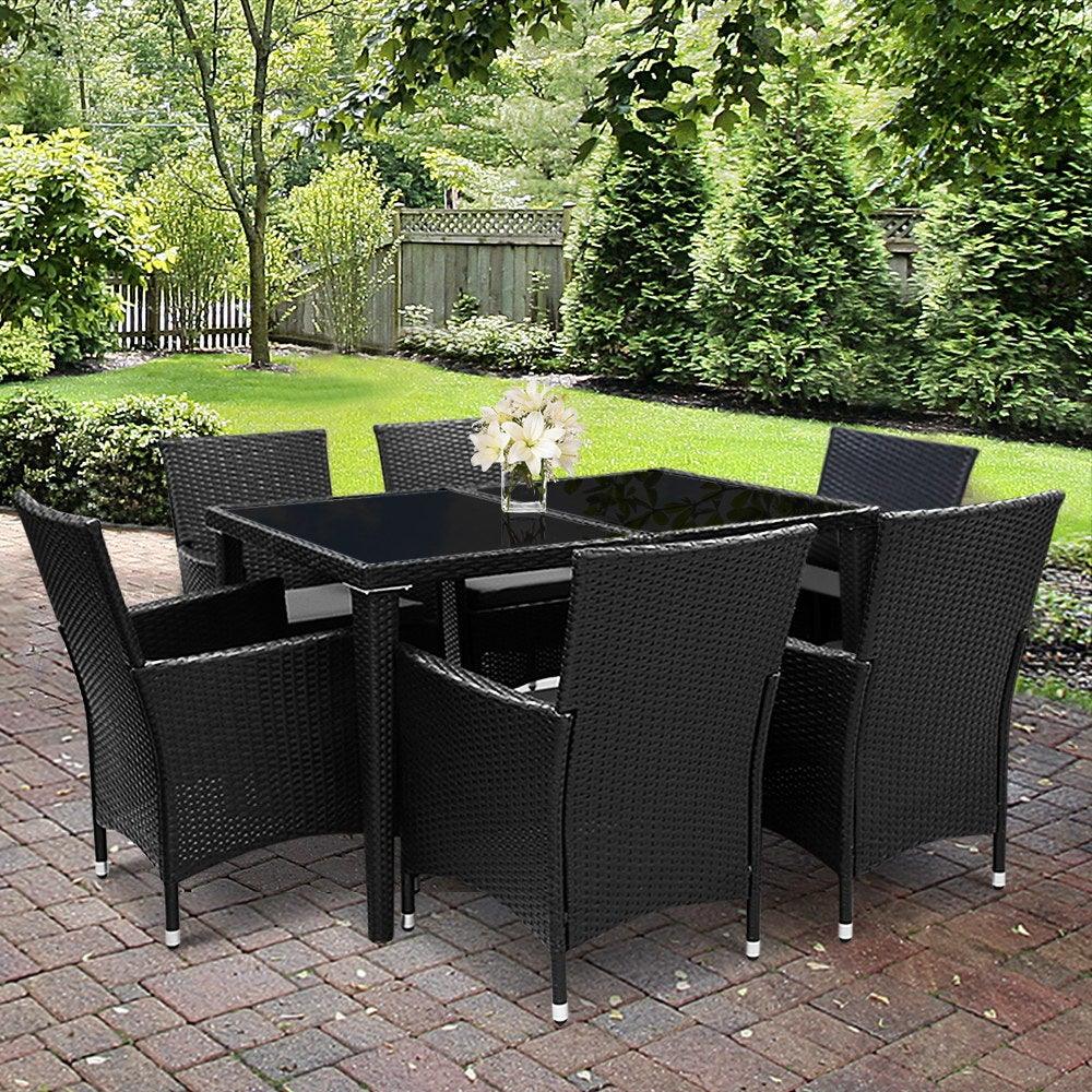 Protective water-resistant cover fully enclosing seven-piece outdoor dining set