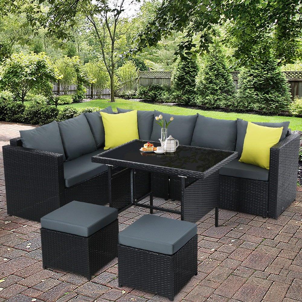 Stylish black wicker patio lounge set arranged for comfortable outdoor seating and dining.