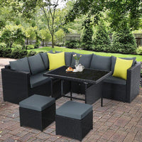 Stylish black wicker patio lounge set arranged for comfortable outdoor seating and dining.