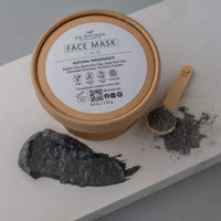 Close-up of calm face mask cream in jar surrounded by natural plants.