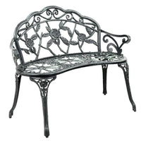 Green Victorian garden bench with ornate aluminum seat and floral backrest outdoors.