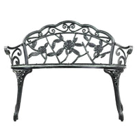 Close-up of floral-patterned backrest of green Victorian garden bench.