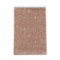 Copper Magnolia Tea Towel displayed folded on a kitchen counter with soft natural light.