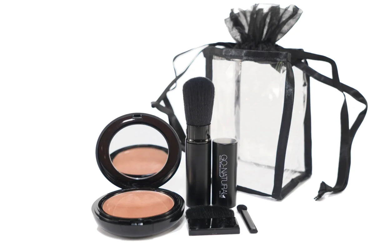 Contents of GO NATURAL travel gift set including powder compact, brush, and pouch on white.