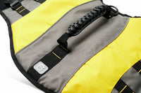 Large dog wearing the bright yellow life jacket with chin flotation flap near the head.