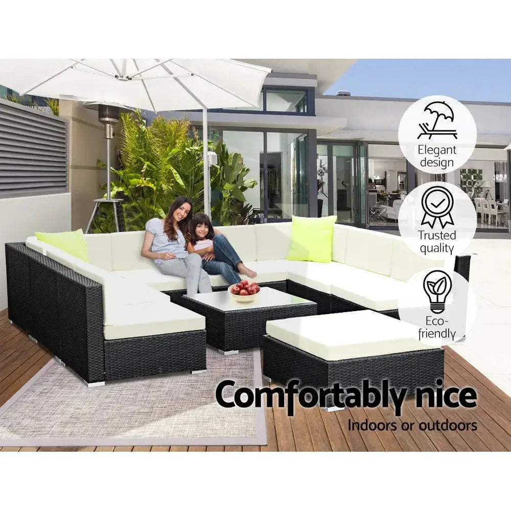 Outdoor wicker sofa set arranged with cushions and pillows for seating.