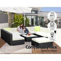 Outdoor wicker sofa set arranged with cushions and pillows for seating.