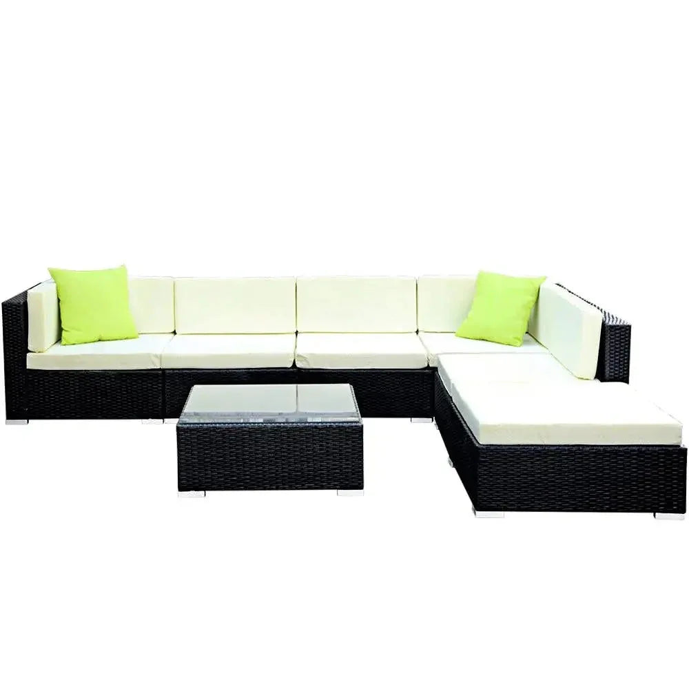 Outdoor wicker furniture set with beige cushions showing seating and glass topped table.