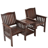 Two-seater outdoor wooden garden bench with integrated table in charcoal brown finish on patio.