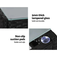 Gardeon outdoor lounge setting shielded by fitted black cover in garden setting.