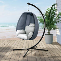 Relaxing outdoor egg hammock chair pod with soft cushion in neutral color.
