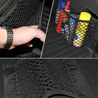Car trunk mesh net organizer holding a fire extinguisher and other small items.