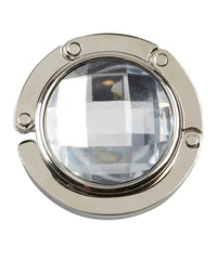 White handbag hanger with magnetic closure folded flat on white surface.