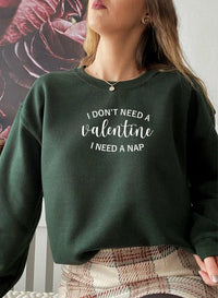 Man wearing black sweatshirt with 'I Don't Need A Valentine' text, standing against white background.