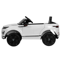 Close-up of dashboard and steering wheel inside white ride on Land Rover toy car.