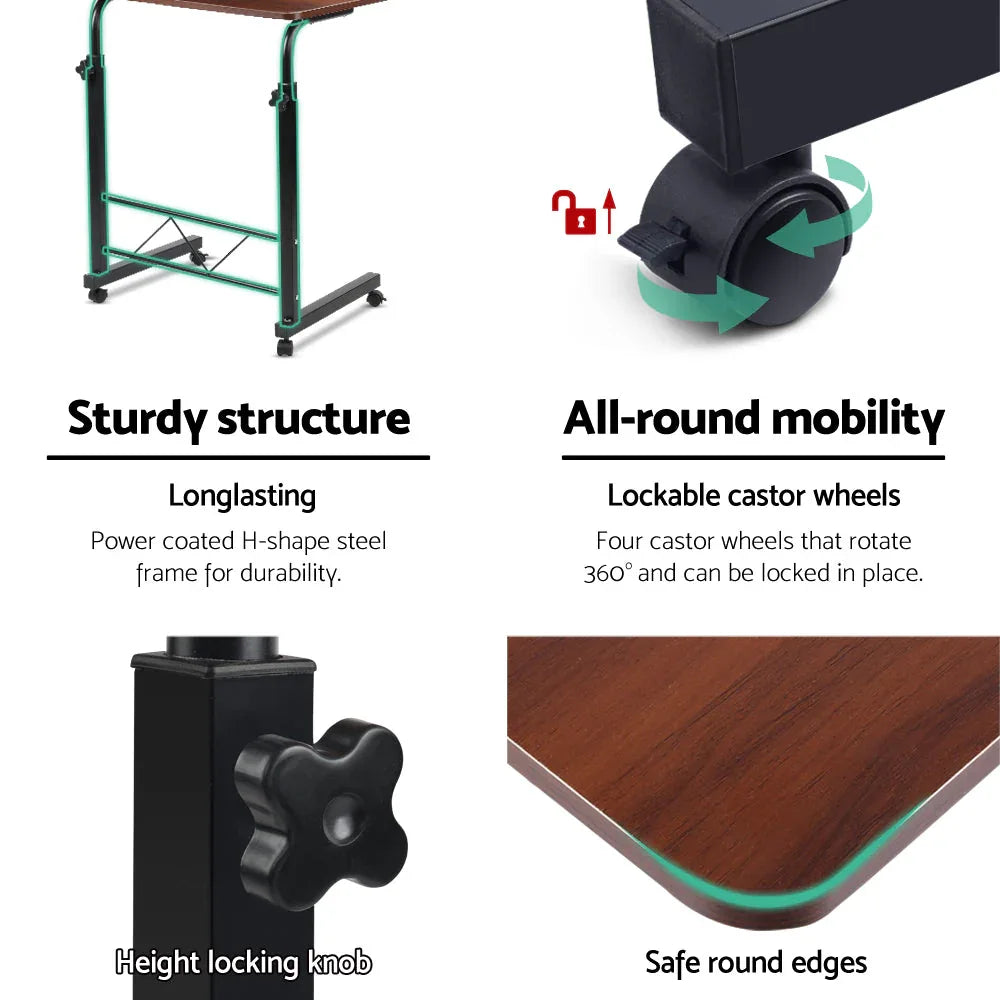 Mobile laptop desk adjusted in height placed next to bed for convenient personal workspace.