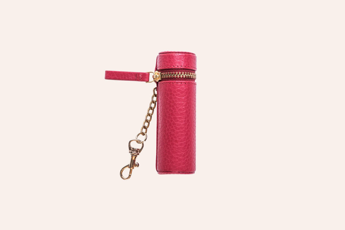 Lipstick keeper pouch beside a tube of lipstick on wooden surface