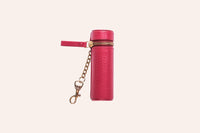 Lipstick keeper pouch beside a tube of lipstick on wooden surface