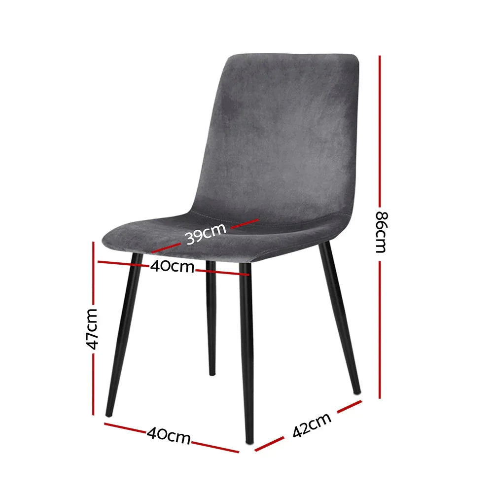 Close-up of grey velvet upholstered modern dining chair with solid iron legs on wooden floor.