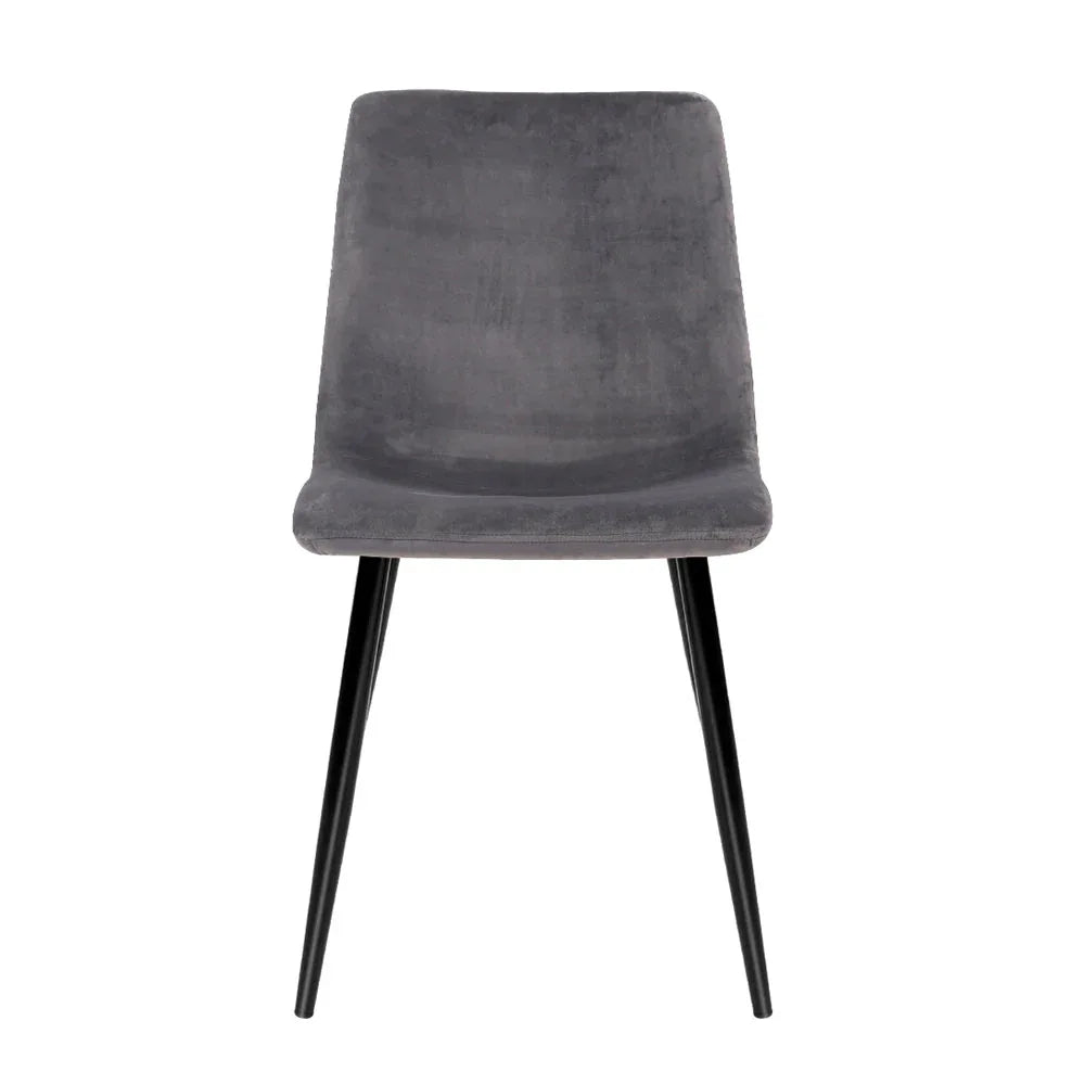 Side view of grey modern dining chair showing velvet seat and sturdy iron frame and legs.