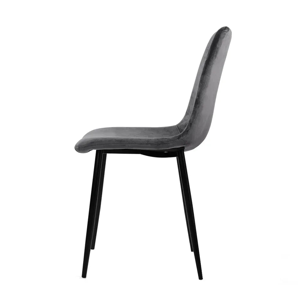 Back view of grey velvet dining chair highlighting curved backrest and iron legs.