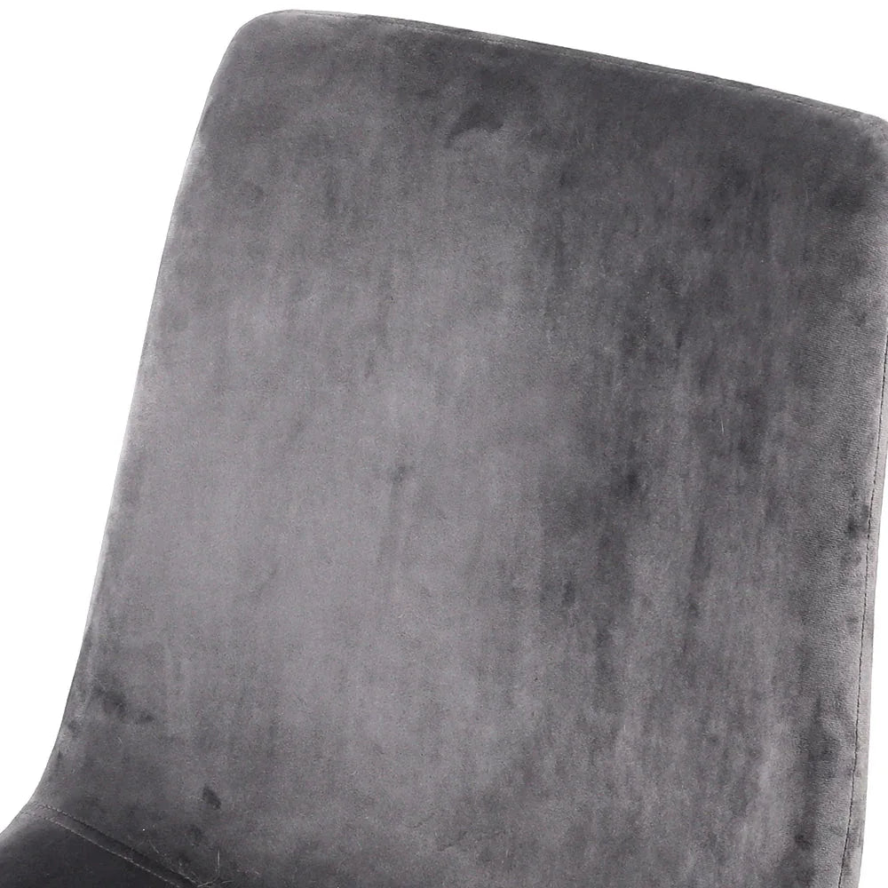 Set of four modern dining chairs with grey velvet seats and black iron legs grouped together.