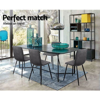 Dining chair with wide comfortable grey velvet seat and iron legs, shown against white background.
