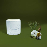 White marble ceramic vessel from Bear Hug candle with soft lighting highlighting its gray and black swirls.