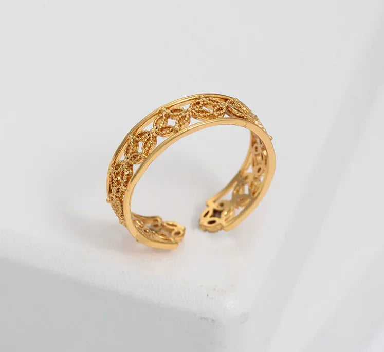 Close-up of the adjustable Hélodie Ring with a sleek gold band on a white background