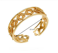 Detailed view of slim, adjustable gold ring with polished finish on neutral backdrop