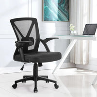 Low angle showing base and wheels of a black ergonomic mesh office chair in a studio setting.