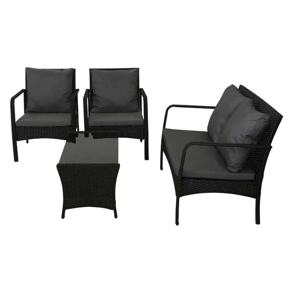 Tempered glass top table with non-slip pads, part of black wicker garden lounge set.