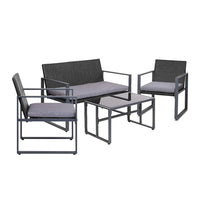 Black four-piece outdoor patio furniture set with table and cushioned chairs on patio.