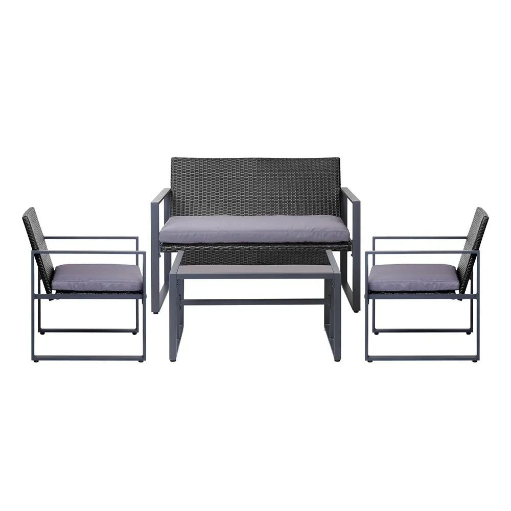 Side view of cushioned black patio chairs around glass-top table on wooden deck.
