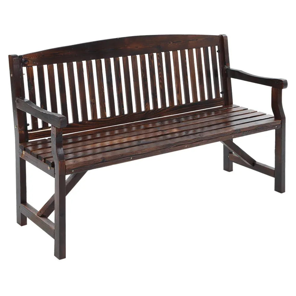 Natural wooden garden bench with armrests placed on outdoor stone patio