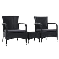 Outdoor conversation set with two black wicker chairs and a matching small table on a patio.