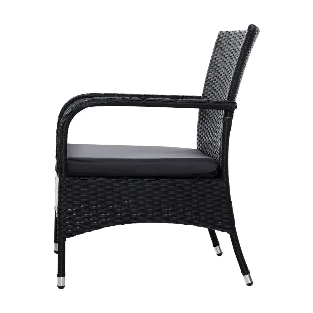 Black wicker chair showing woven pattern and cushions with an outdoor background.