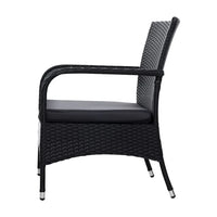 Black wicker chair showing woven pattern and cushions with an outdoor background.