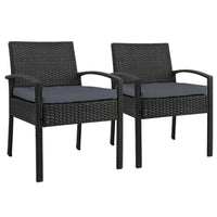 Set of 2 black wicker outdoor dining chairs with cushions on wooden patio floor