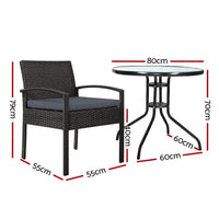 Outdoor wicker dining set showing one chair with beige cushion next to table with parasol hole.