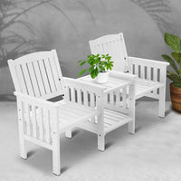 Wide shot of 2-seater wooden garden bench and table set placed on patio floor outdoors.
