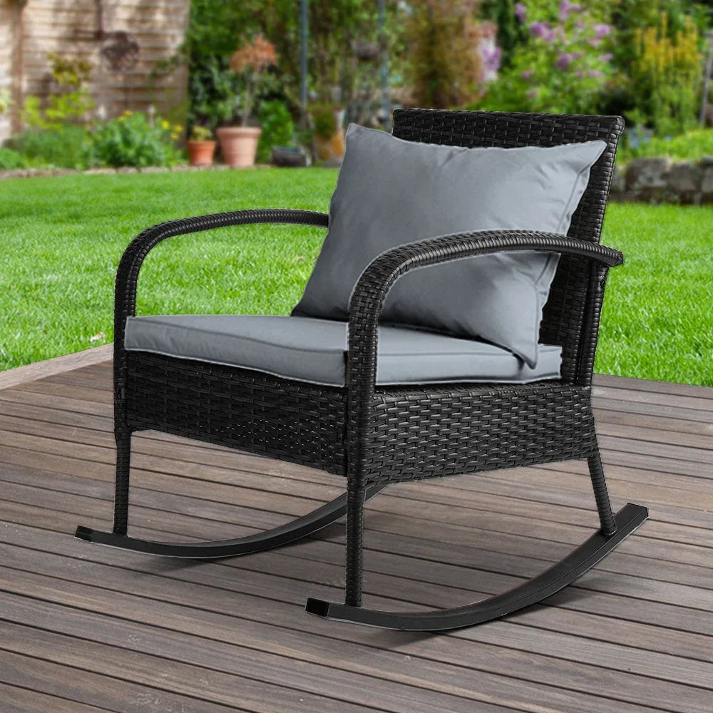 Gardeon black resin rattan rocking chair with soft cushions on a porch floor.