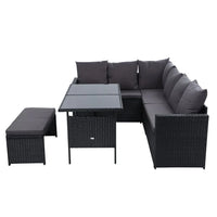 Outdoor sectional sofa with black wicker frame and soft cushions arranged on wooden patio